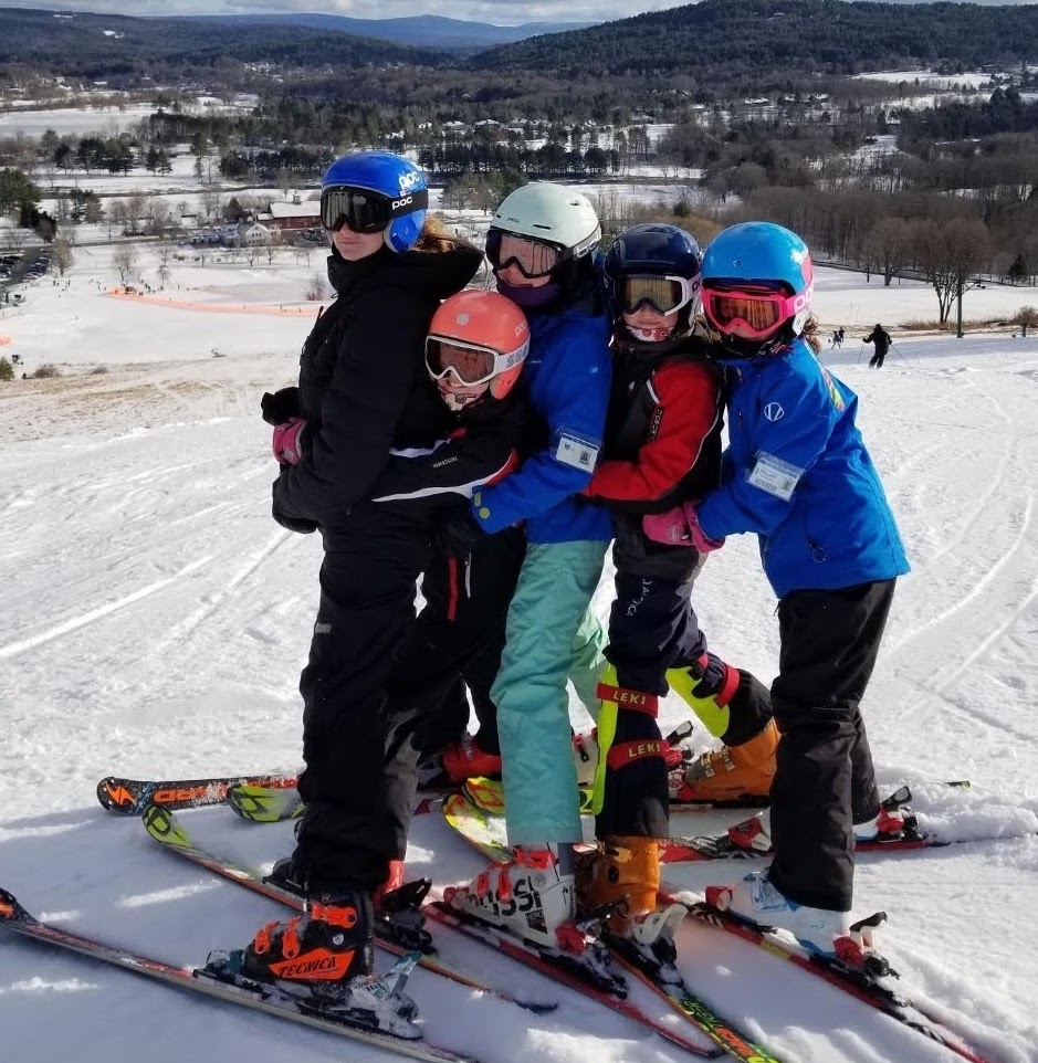 Quechee ski team kids huddled together on the mountain for a picture